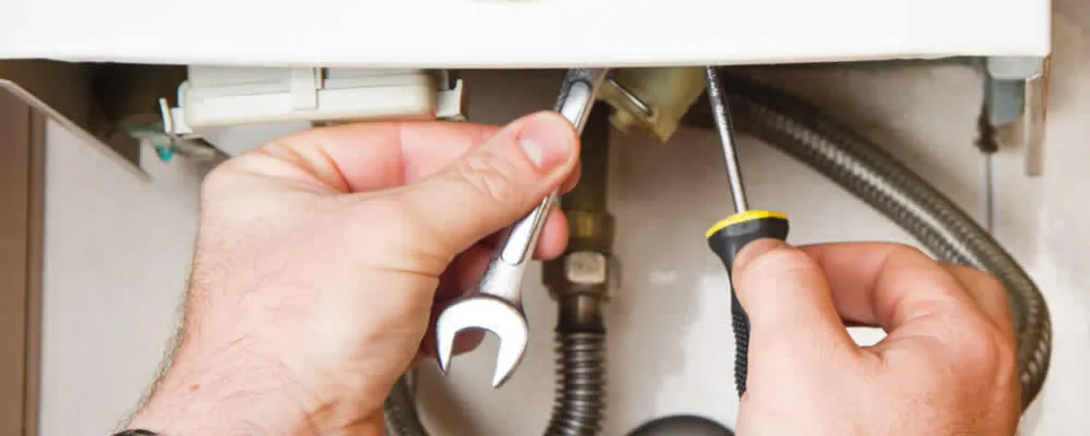Boiler repair technician tightening pipe fittings and connections in Pittsburgh, PA