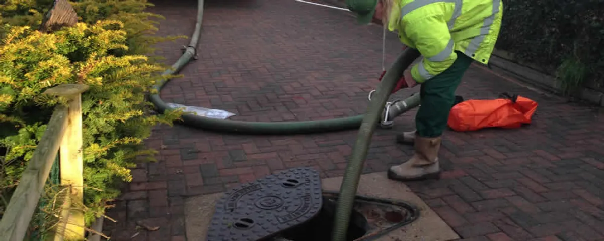 Septic tank cleaning technician servicing a septic tank with a vacuum hose in Pittsburgh, PA